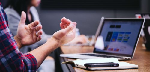 people at table in front of laptop and mobile phone